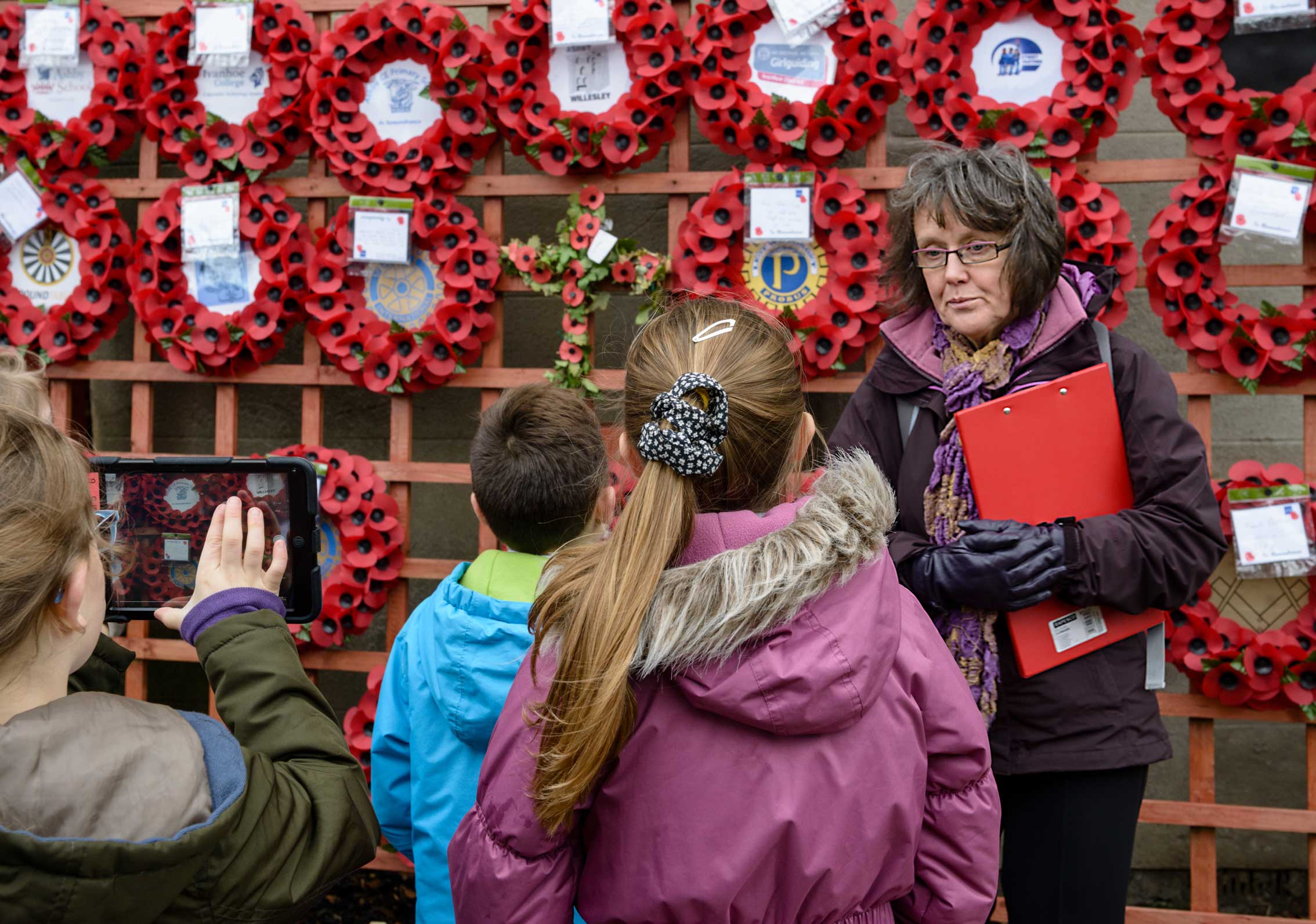 A group of children learning carring out a condition survey on a war memorial.