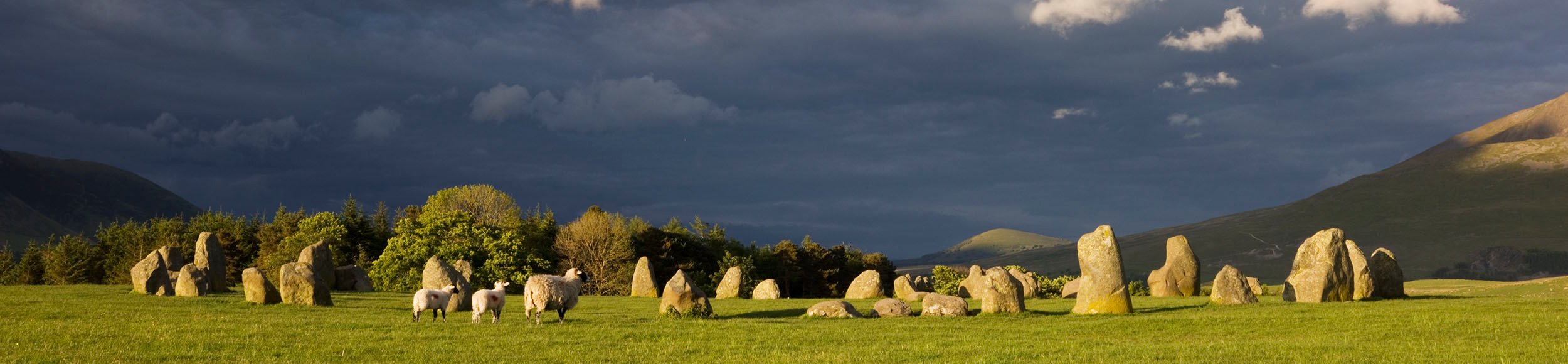 The prehistoric stone circle at Castlerigg with dark skies in the background