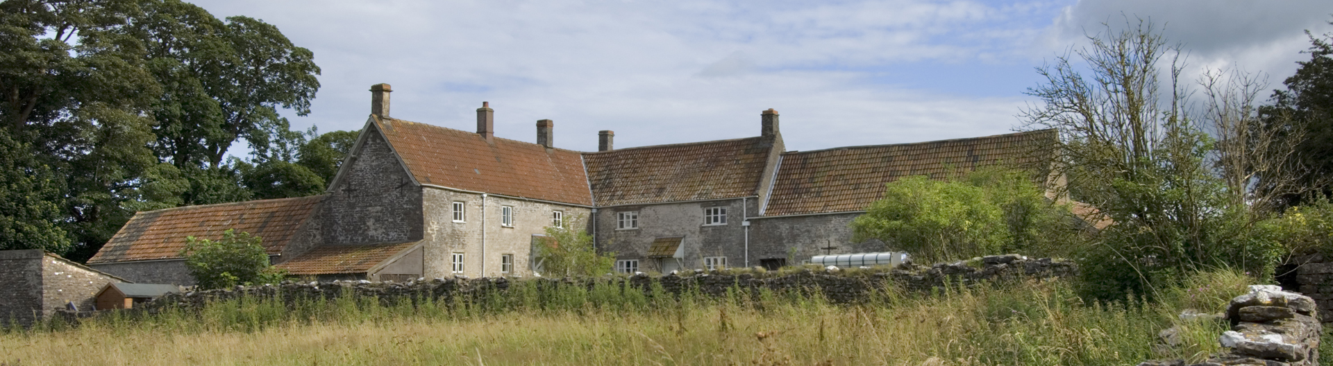 L-shaped stone farmstead in rural setting in Priddy, Somerset
