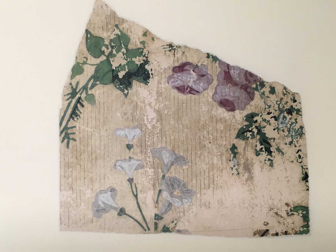 A detail of a historical wallpaper with a floral pattern of white and mauve flowers. The green pigment contains arsenic.