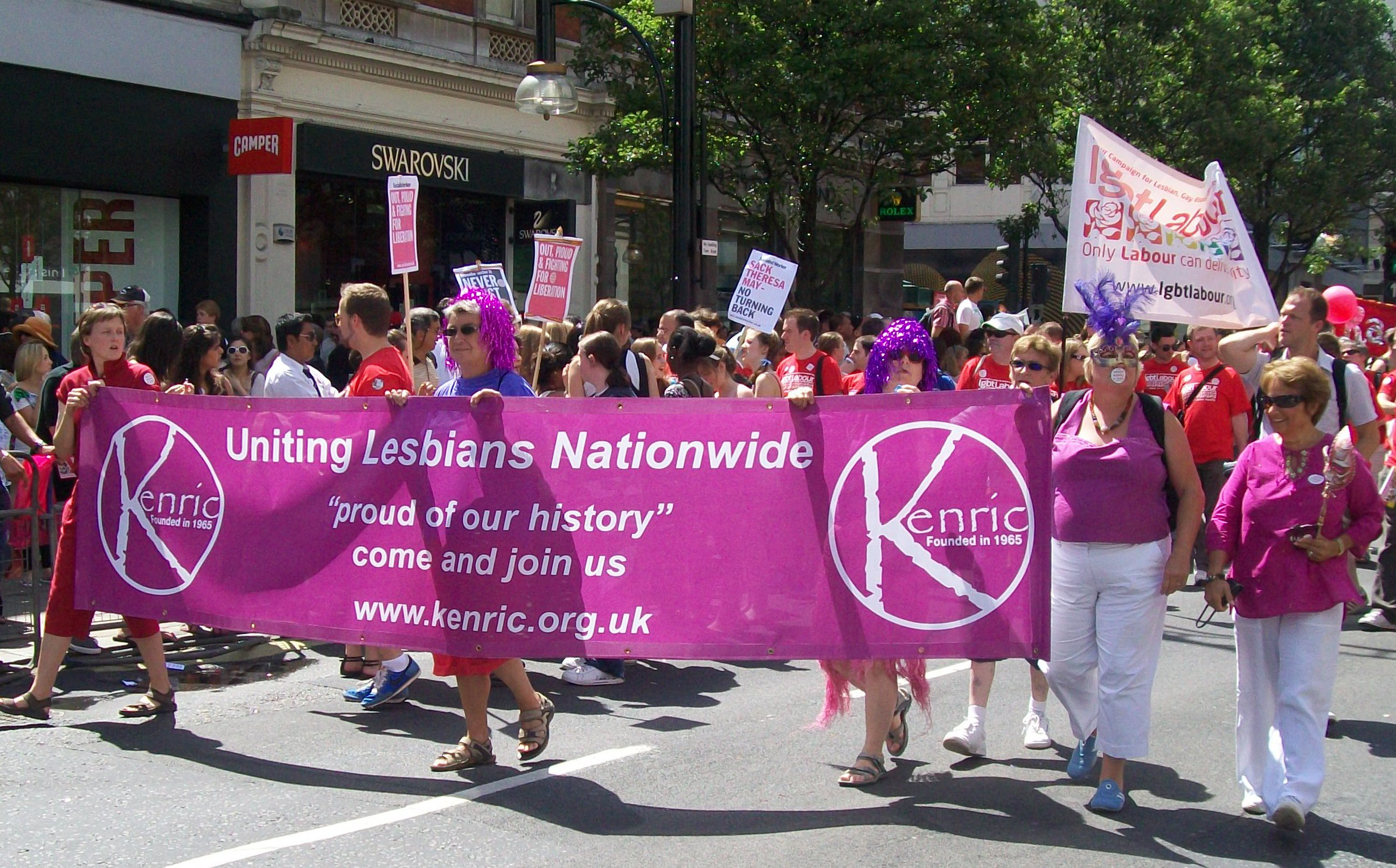 Marchers carrying Kenric banner with wording: 
Uniting Lesbians Nationwide
"proud of our history"
come and join us
www.kenric.org.uk