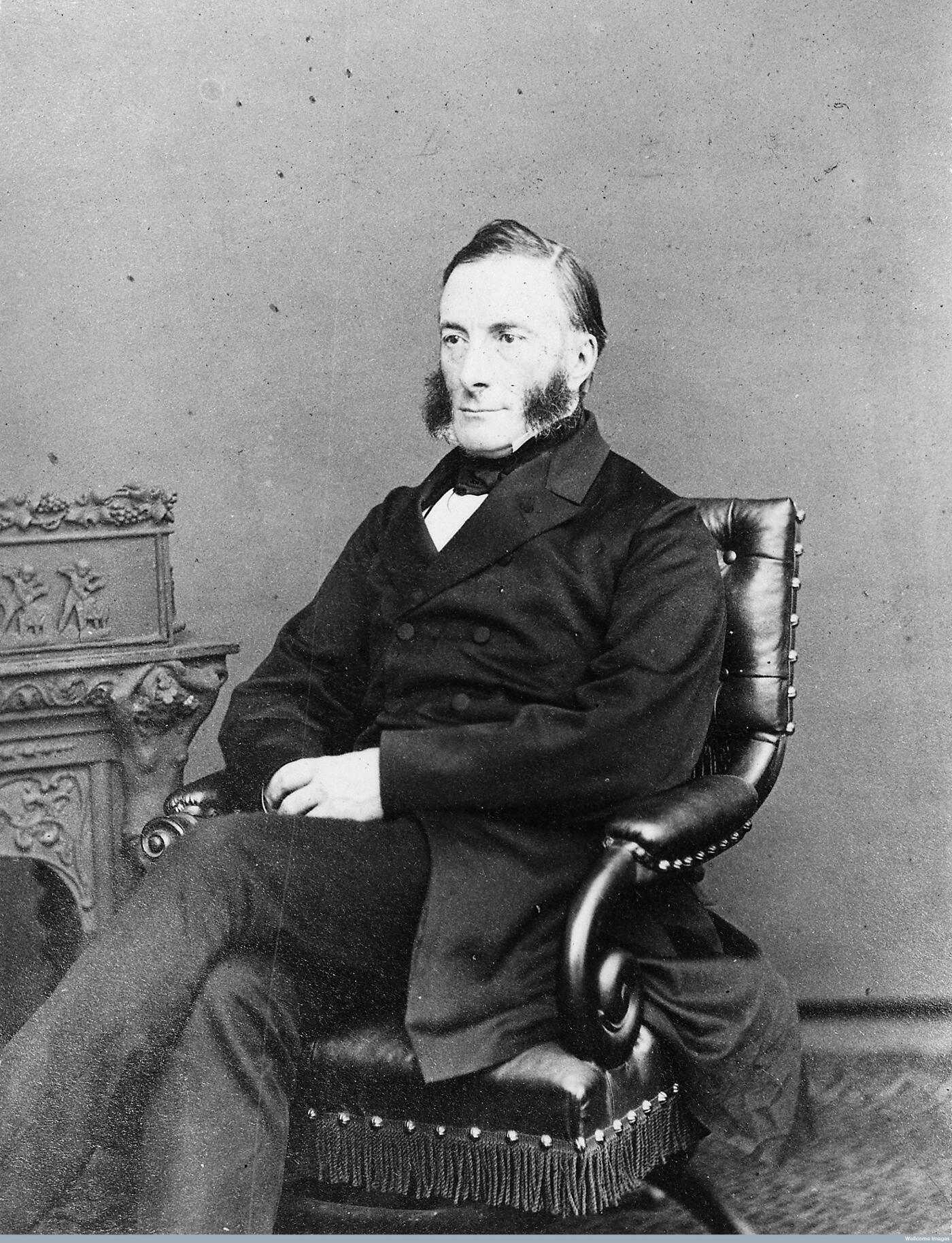 Black and white portrait of a man sitting in a leather chair