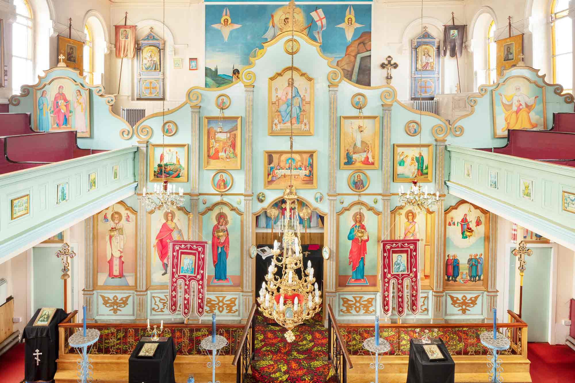 Interior of church shows brightly coloured ‘iconostasis’, a screen of icons depicting Christ, Mary, and the saints. 