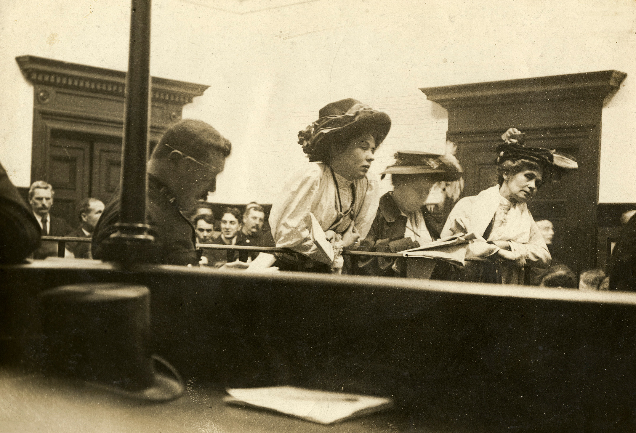 Suffragettes in the dock at Bow Street Court, London. Some of the best-known trials of suffragettes took place at Bow Street Court in the decade before the First World War. Most of the offences by Women’s Social and Political Union (WSPU) members were low-level so would be tried in London’s magistrates’ courts, including Bow Street. In 1908 the WSPU produced a leaflet that urged readers to ‘help the suffragettes to rush the House of Commons’ on 13 October. Its leaders, Emmeline Pankhurst, Christabel Pankhurst and Flora Drummond, were arrested and tried at Bow Street. A press photographer known to the WSPU took covert pictures of the trial showing the three defendants in the dock.