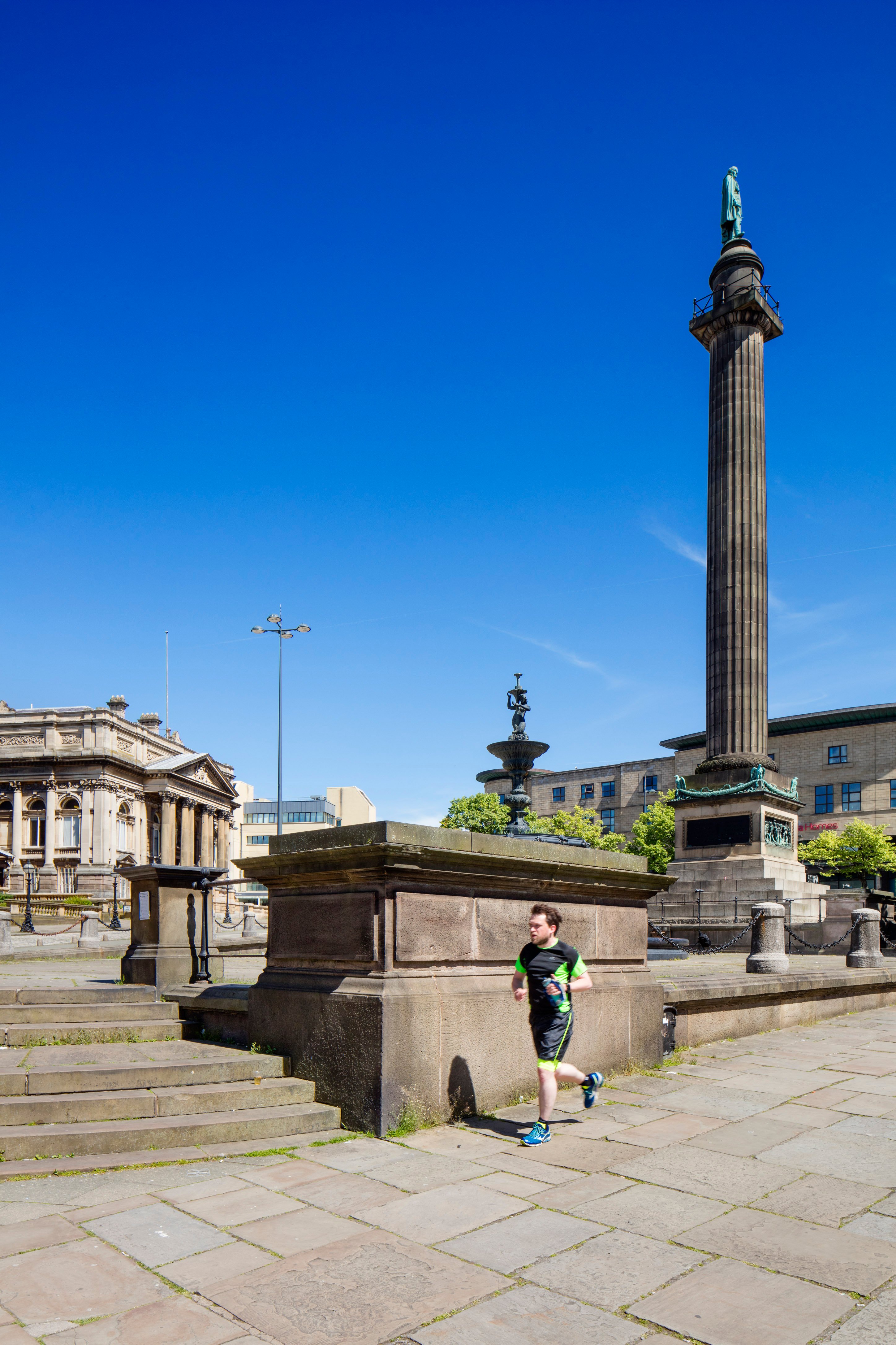 Photograph of the Wellington Column, Liverpool, with a jogger running past its base.