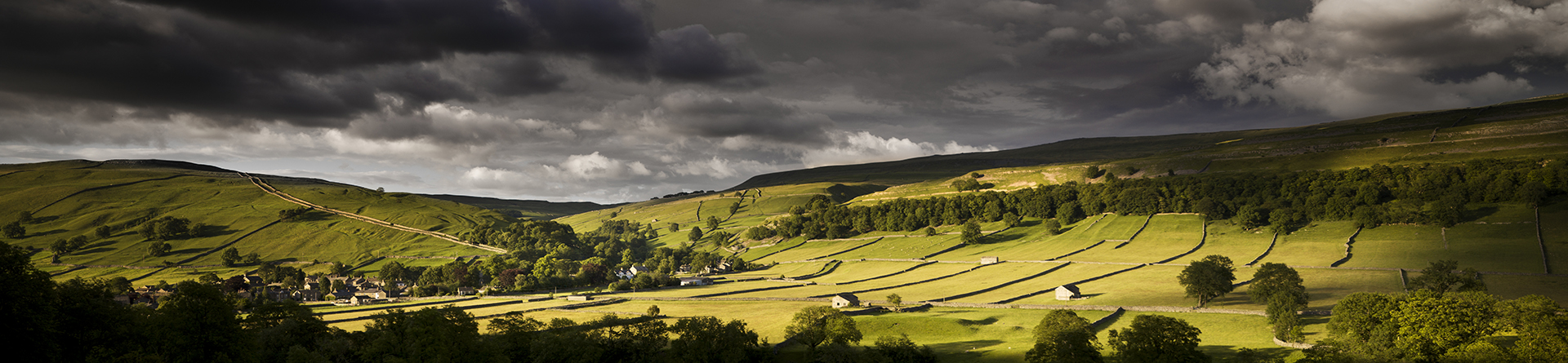 Colour photograph of rural landscape around Kettlewell from the south, showing fields and field barns.