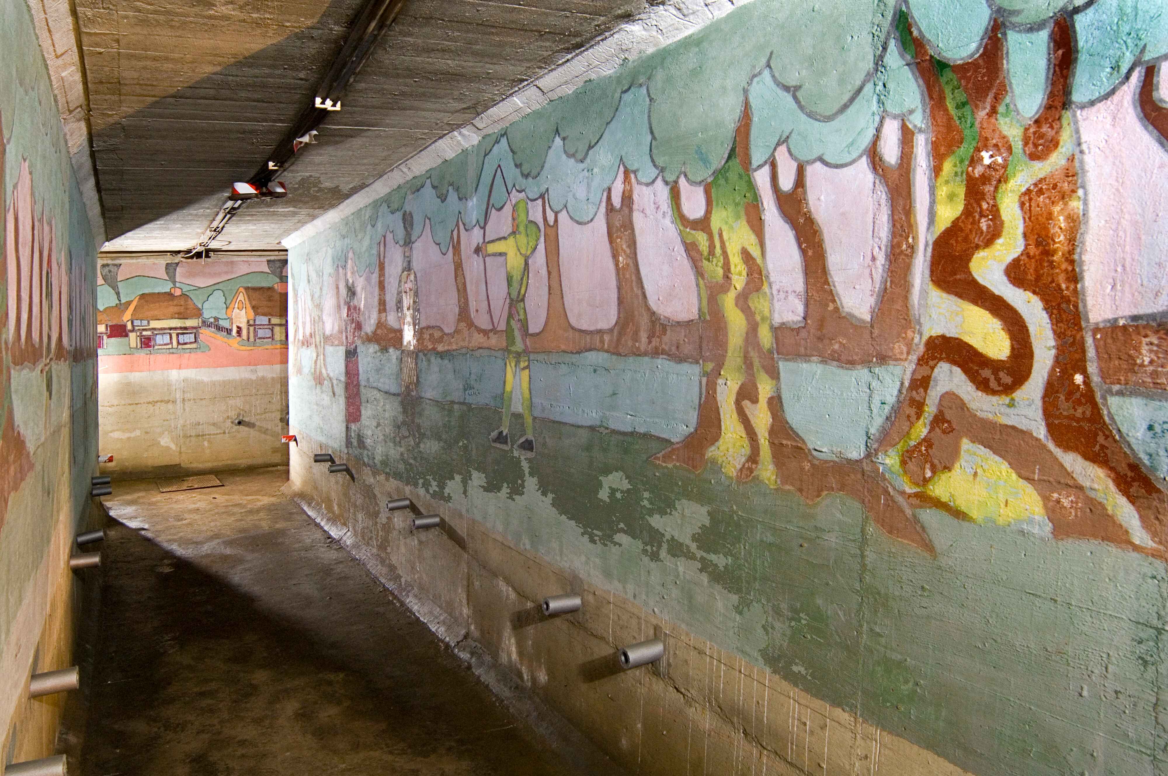 Murals on wall. On the right is a scene from Robin Hood.