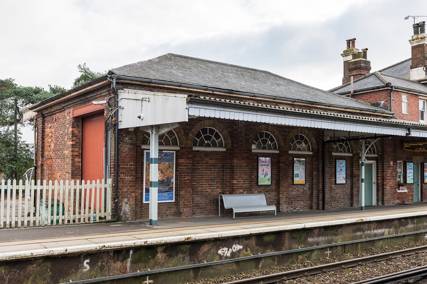 A goods shed, integrated with a passenger station, Pulborough, dating from 1859 featuring and awning on the platform side and lunettes.
