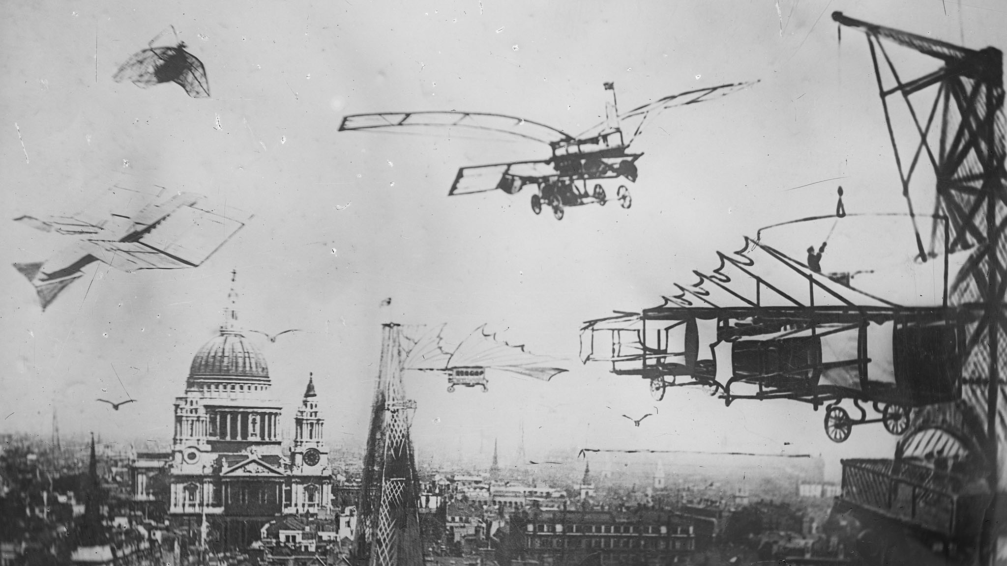 Archive black and white photograph of a city and a domed cathedral, with early imaginary flying machines superimposed on it.