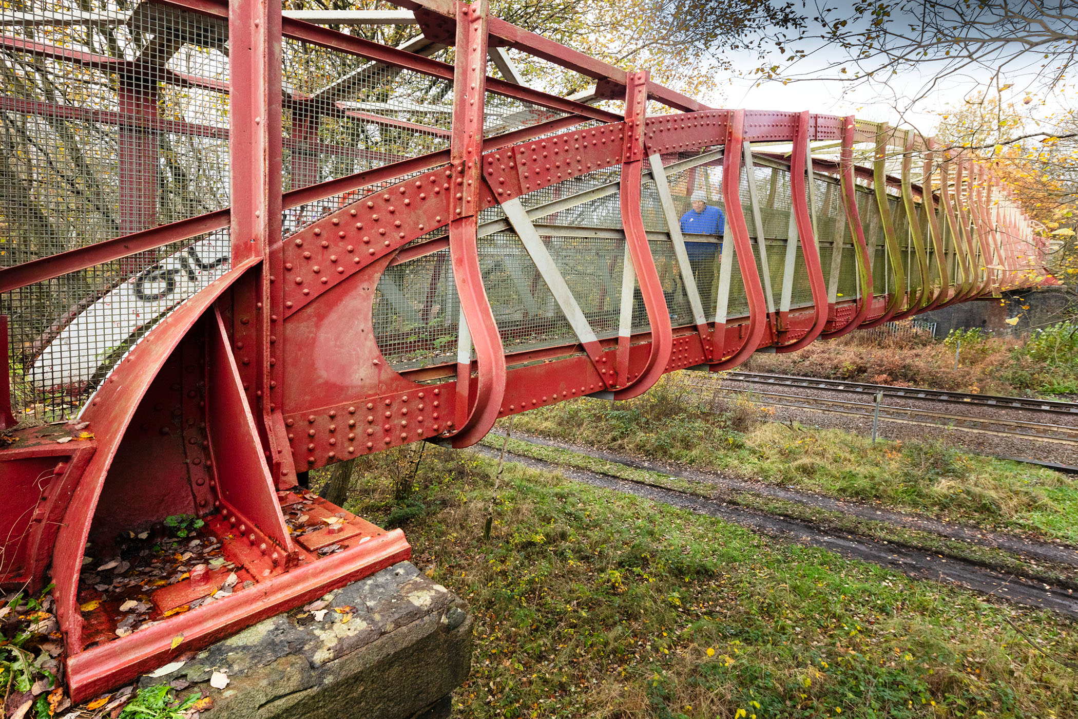 General view of a railway footbridge with red ironwork