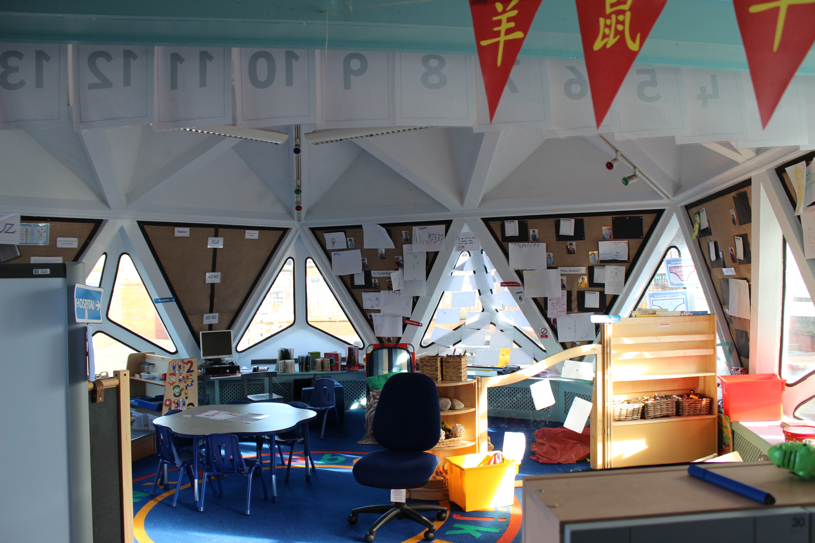 Photo of a classroom inside a domed building with triangular windows, walls and roof panels