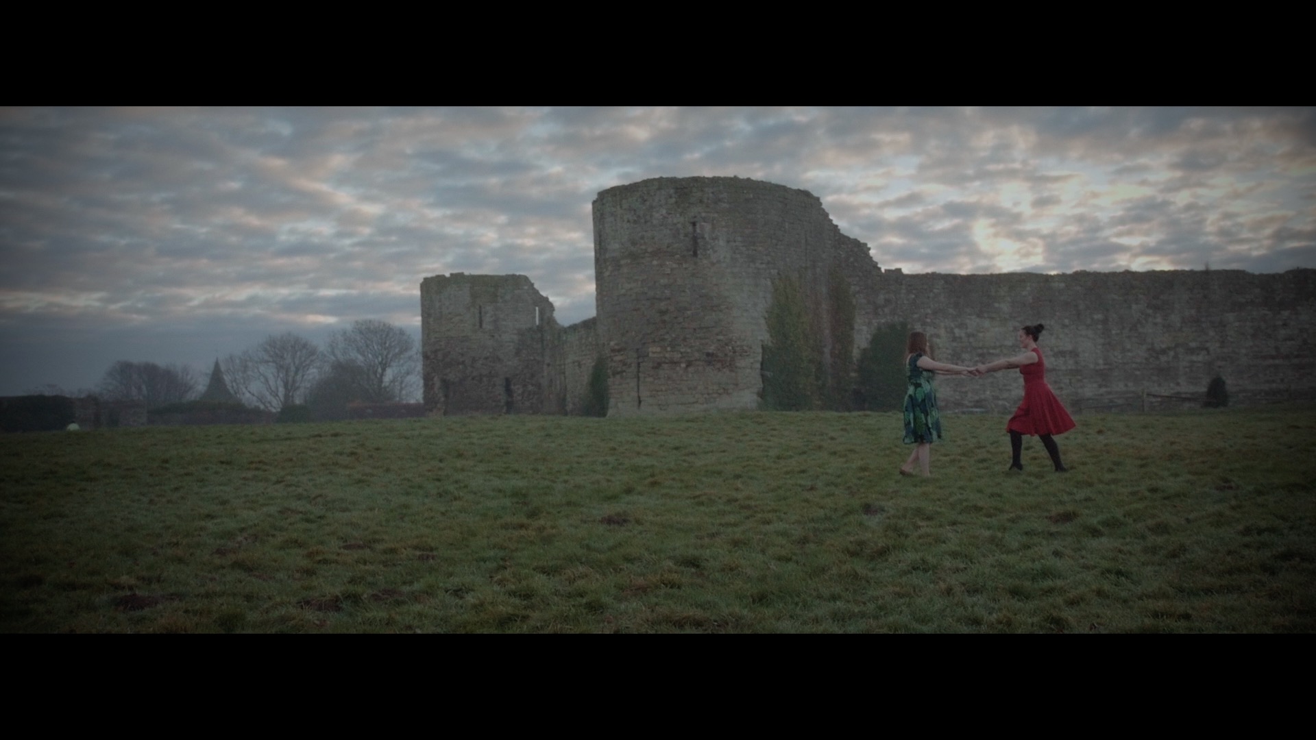 Two women dancing at Pevensey Castle, East Sussex, cared for by English Heritage.