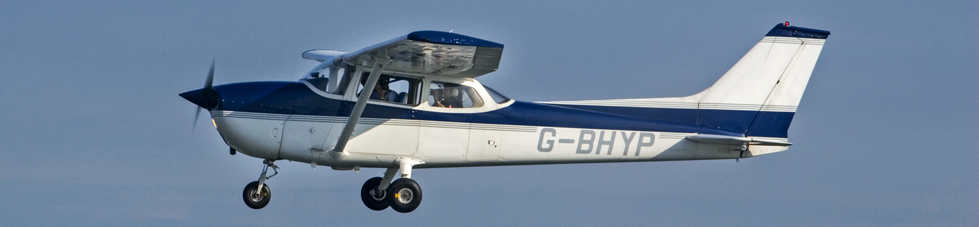 Colour photo showing a high winged single engine pane in flight