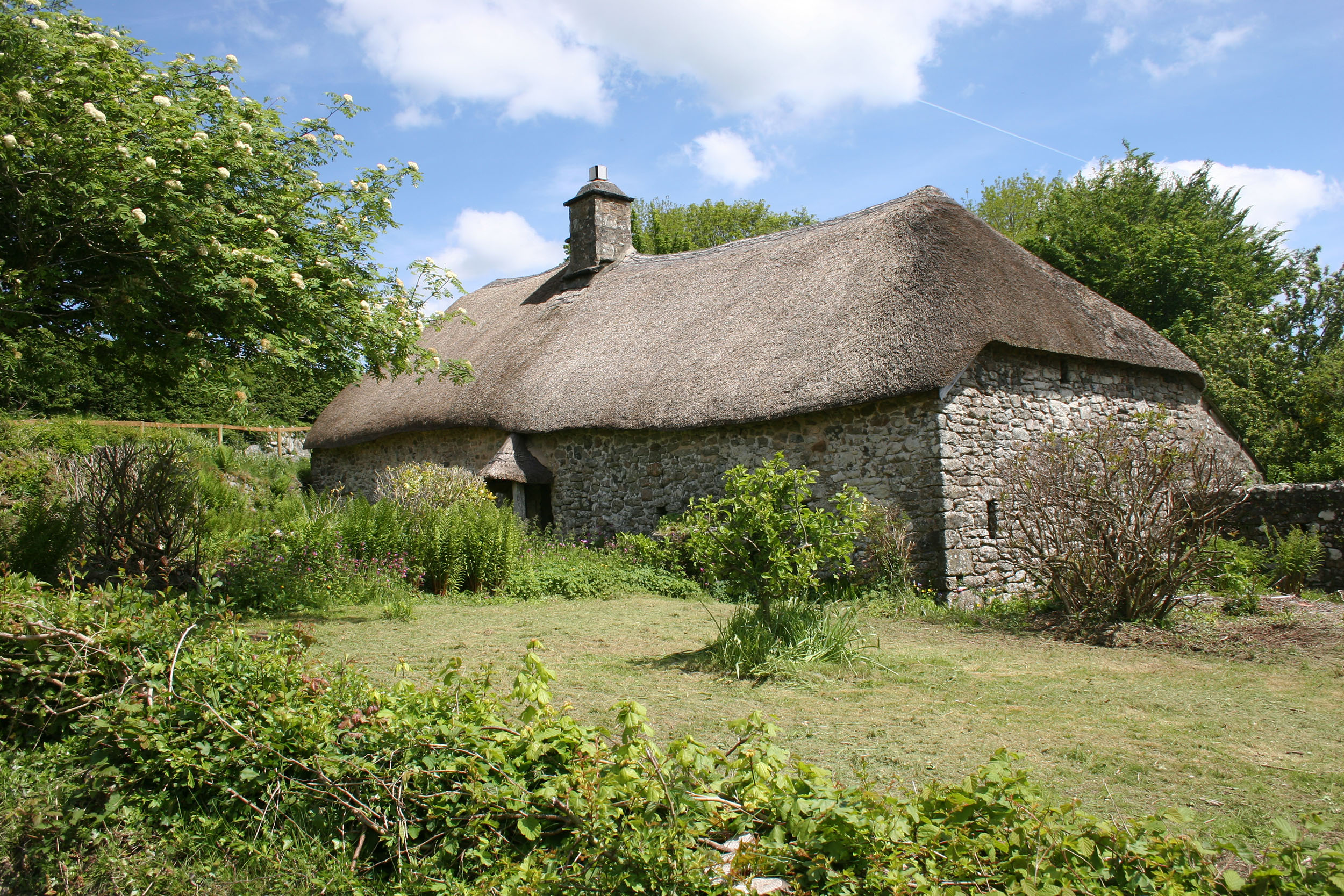 Traditional stone longhouse with thatched roof.