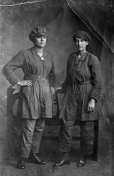 Royal Gunpowder Factory, Waltham Abbey, Essex Protective trousers and tunics were a novelty for women workers at the time. To the right is ‘Miss Kiddy’ wearing a brass war worker’s badge indicative of her service to the war effort. (BB94/08006)