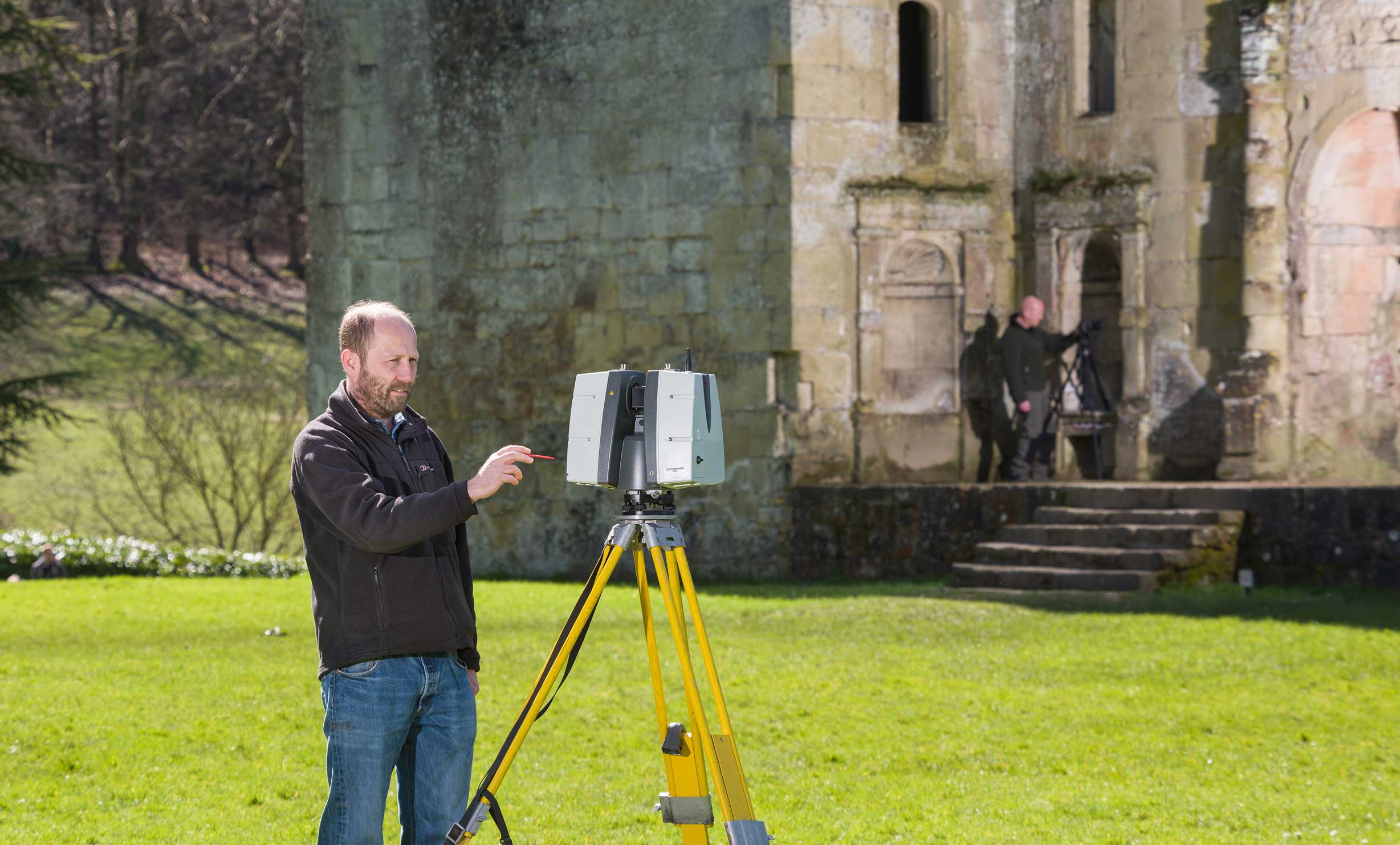 Two people using geospatial survey equipment