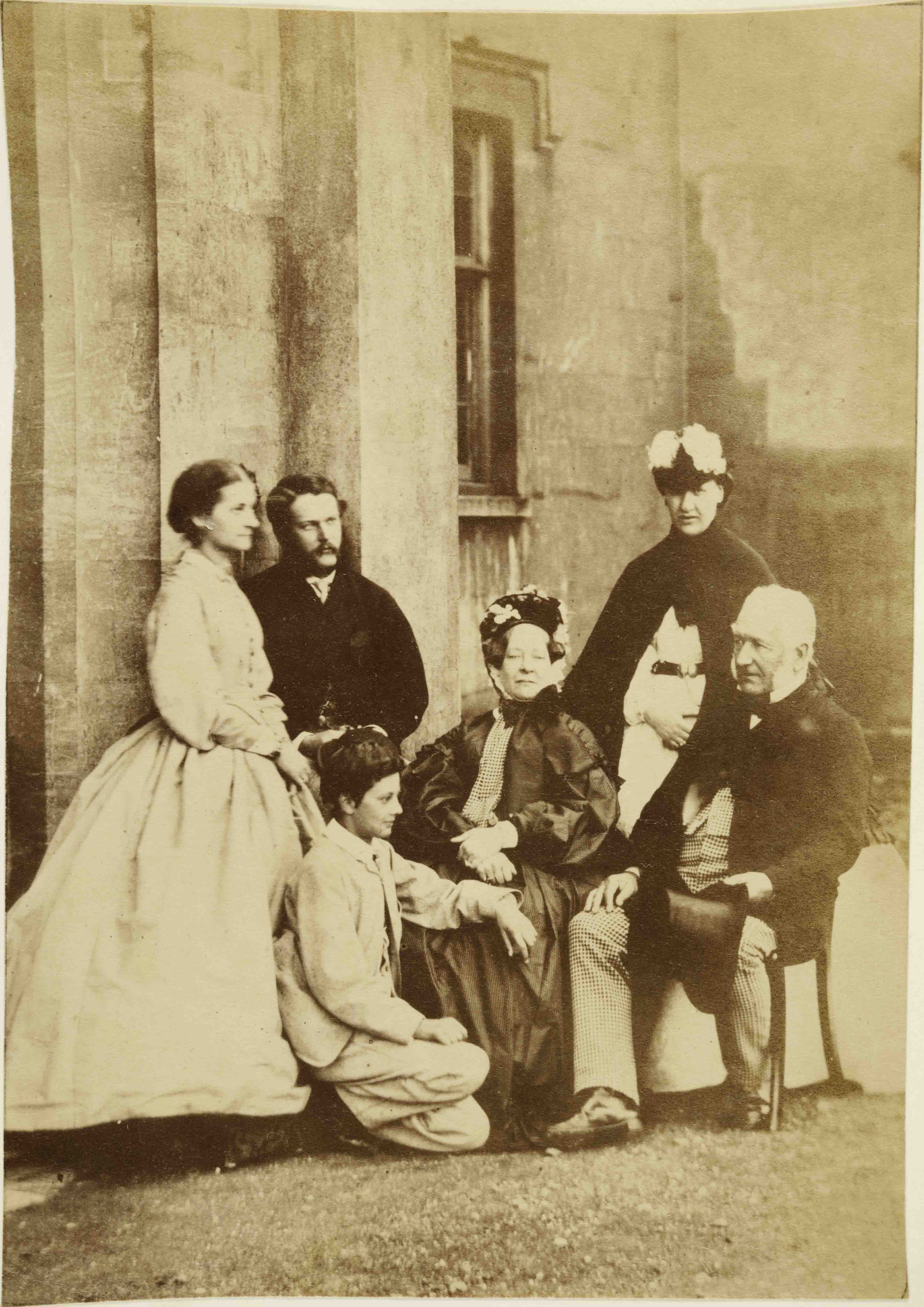 Group of people seated and standing outside building
