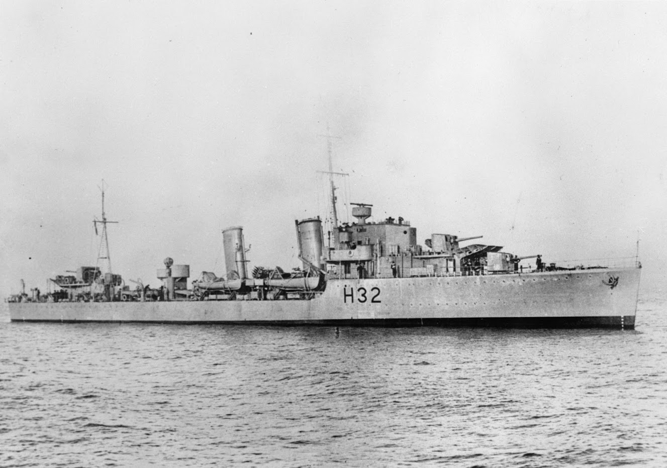 A black and white image of a Second World War destroyer ship on open water