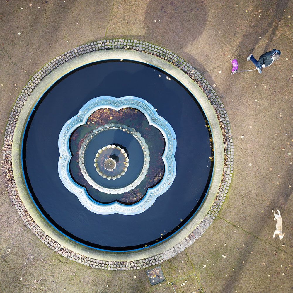 Aerial view of a large round ornamental fountain.