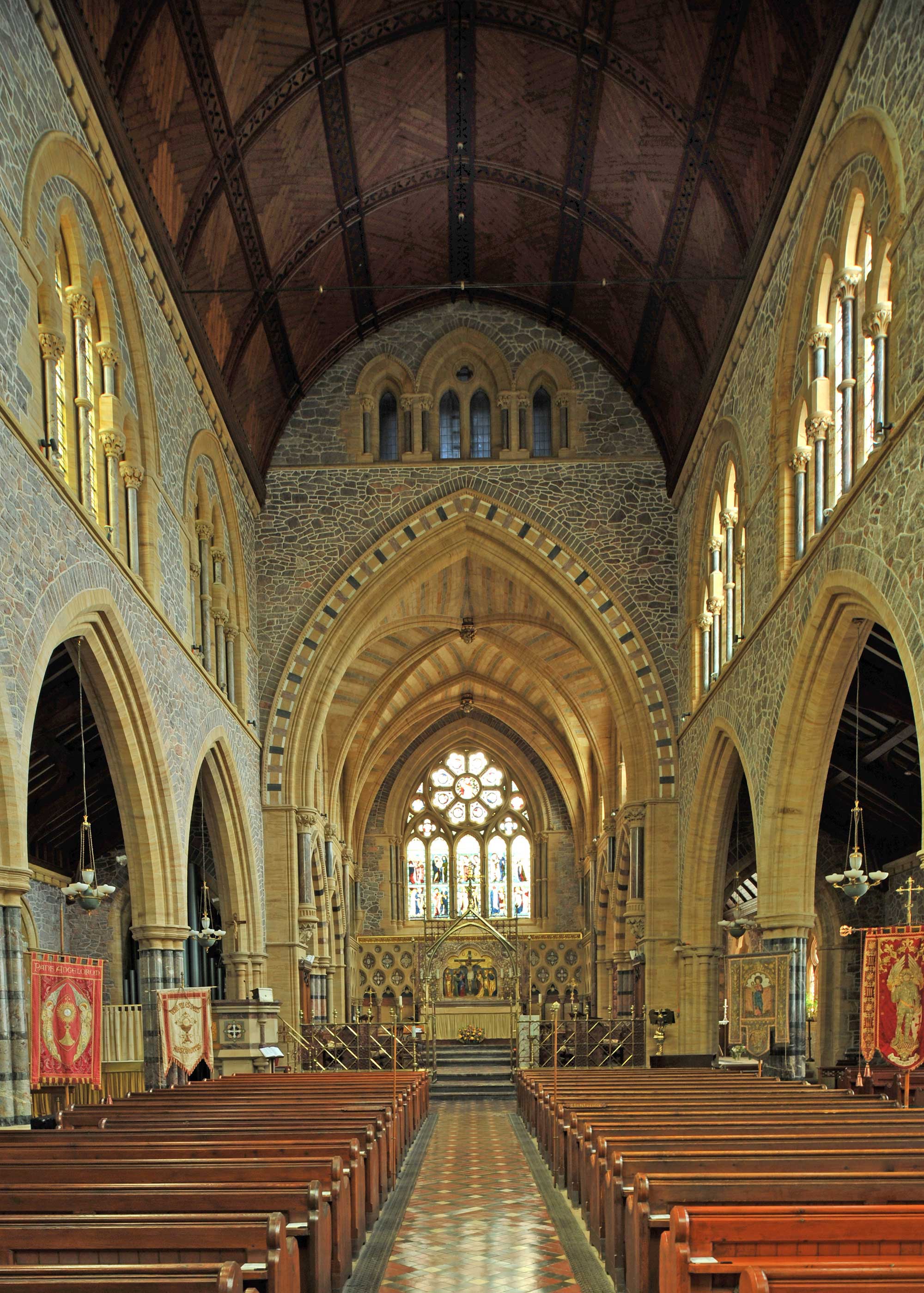 View looking towards the altar. The walls are composed of stone giving a mosaic effect.