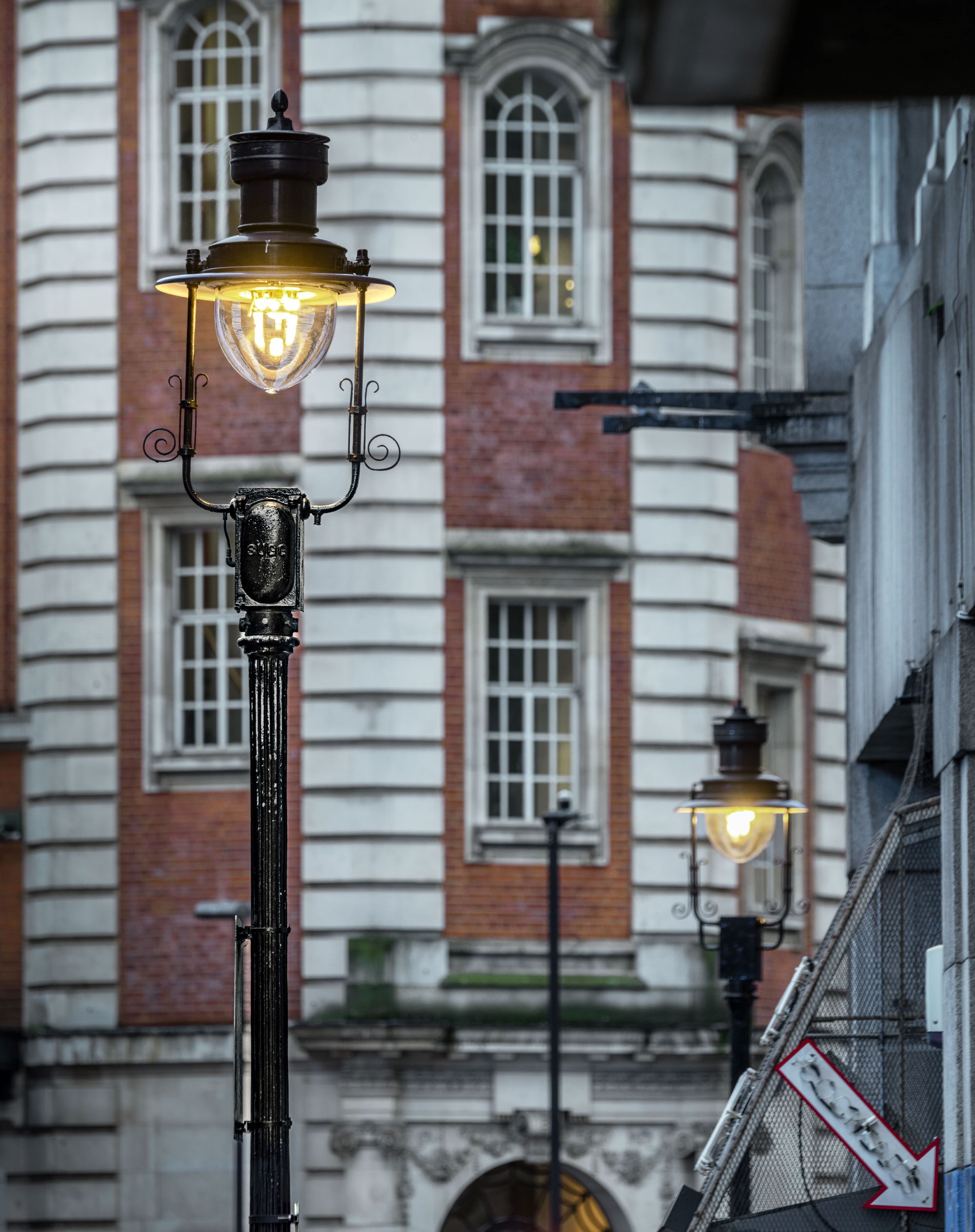 Photo of a black lamppost lit by gas