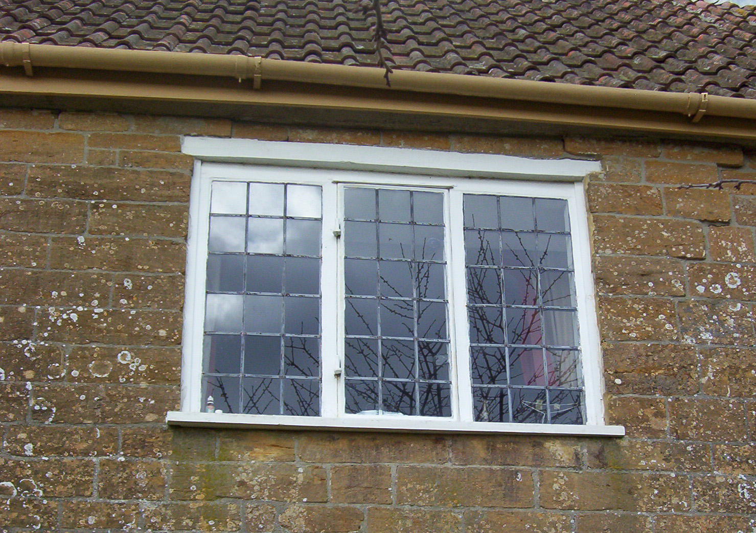 Three-part casement window with leaded panes.
