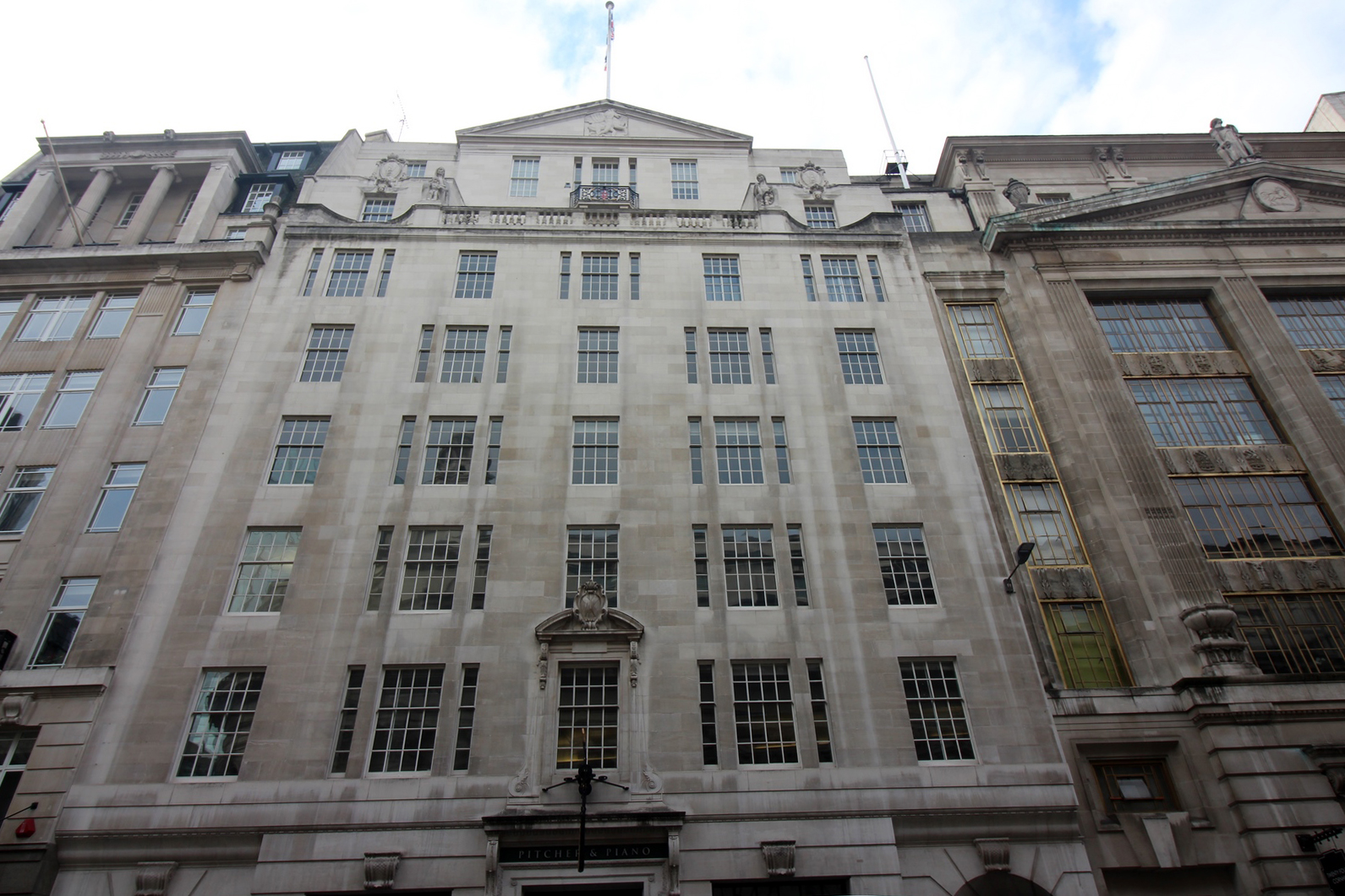 A nine-storey building made of Portland stone with five windows across.