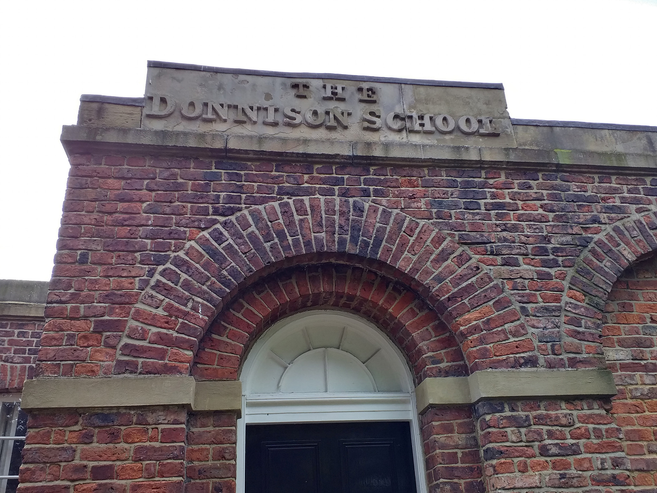 THE DONNISON SCHOOL in top panel above a door in low-relief letters