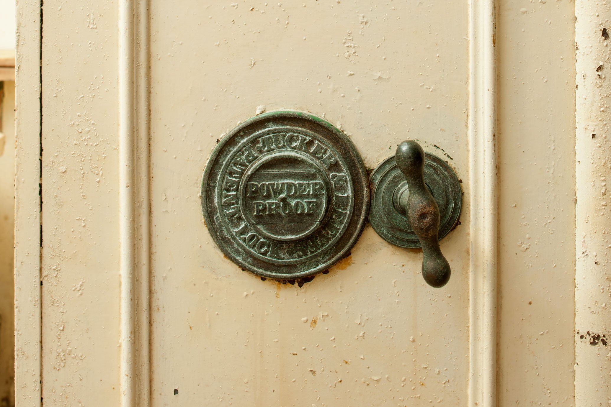 A close up detail of a lock fitting inscribed 'Tucker & Reeves patent lock- powder proof'.