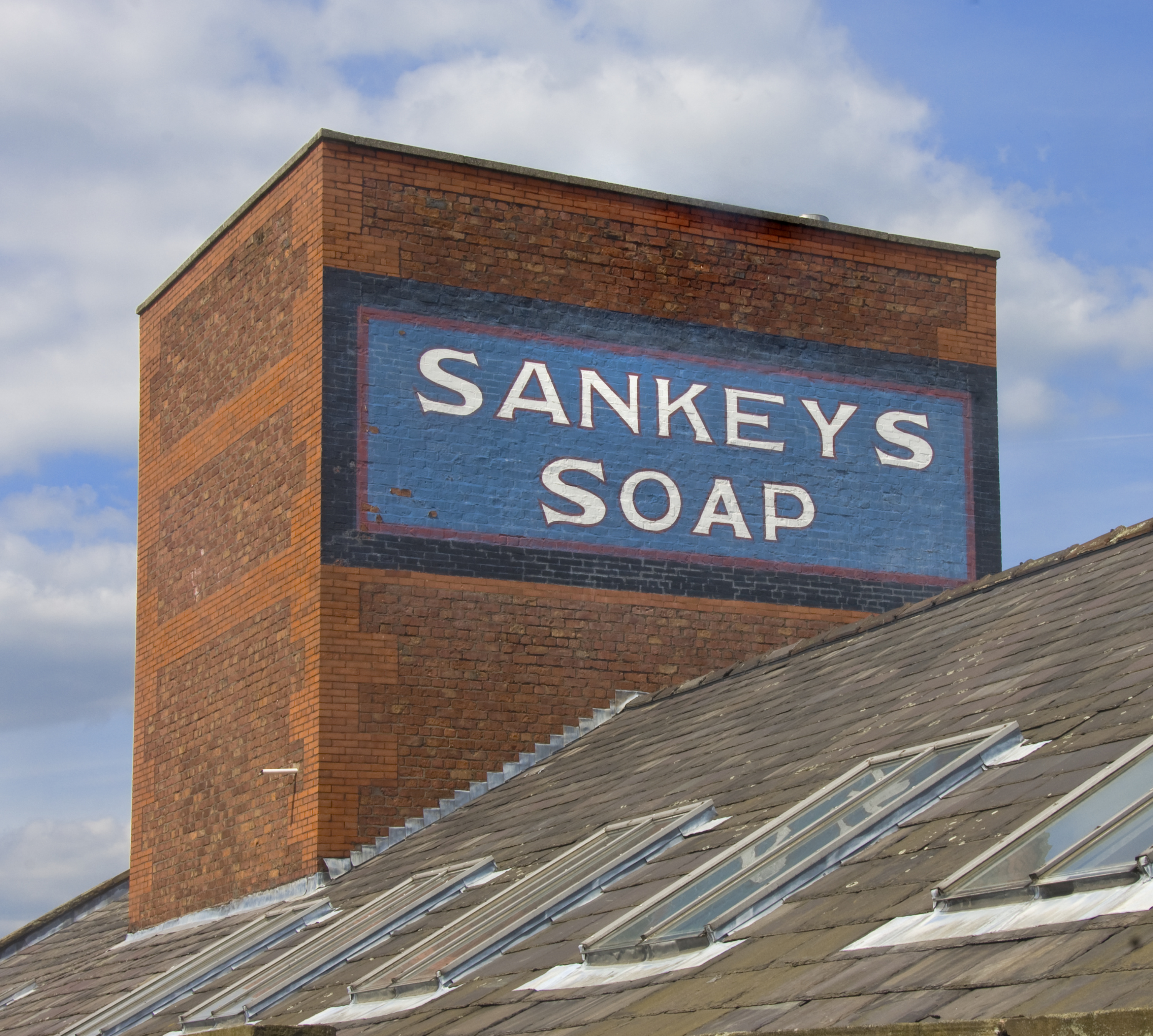 A blue and white sign reading 'Sankey's Soap' on the side of a brick building.