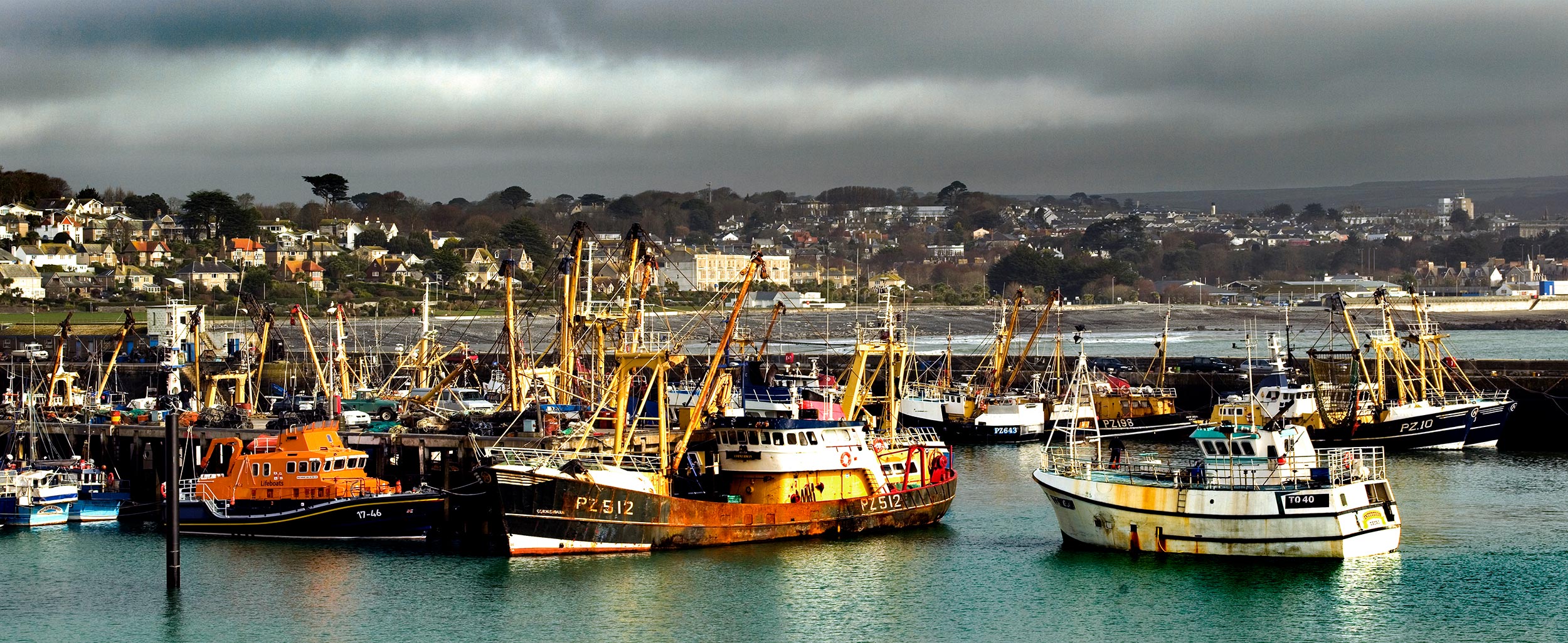 Image of colourful fishing boats anchored at Newlyn harbour, Cornwall.